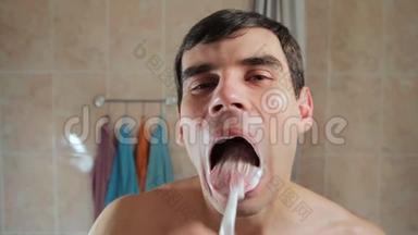 年轻人用牙刷清洁舌头。 口腔护理